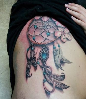  Tatouage attrape rêve avec des gems bleu sur le haut des côtes